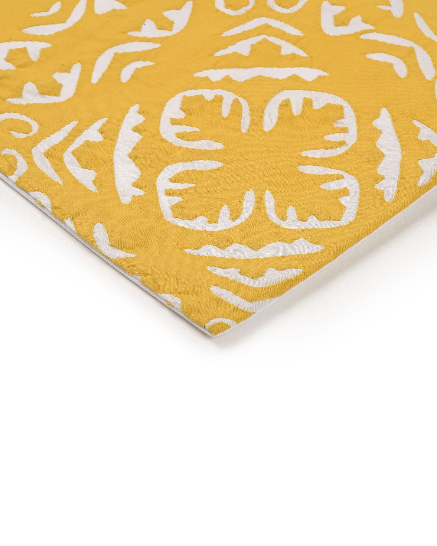 Yellow pillow with white pattern on a gray couch