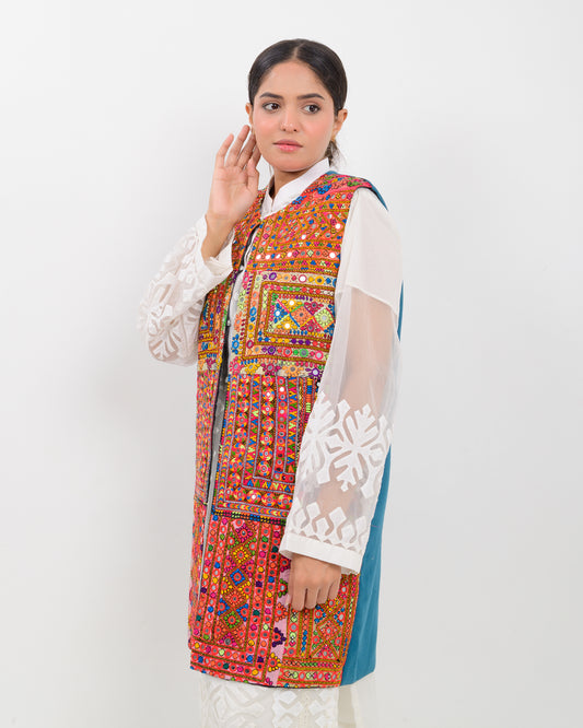 Woman wearing a colorful balochi embroidered vest on a white background