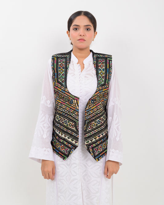 Woman wearing a traditional balochi embroidered vest over a white shirt on a white background