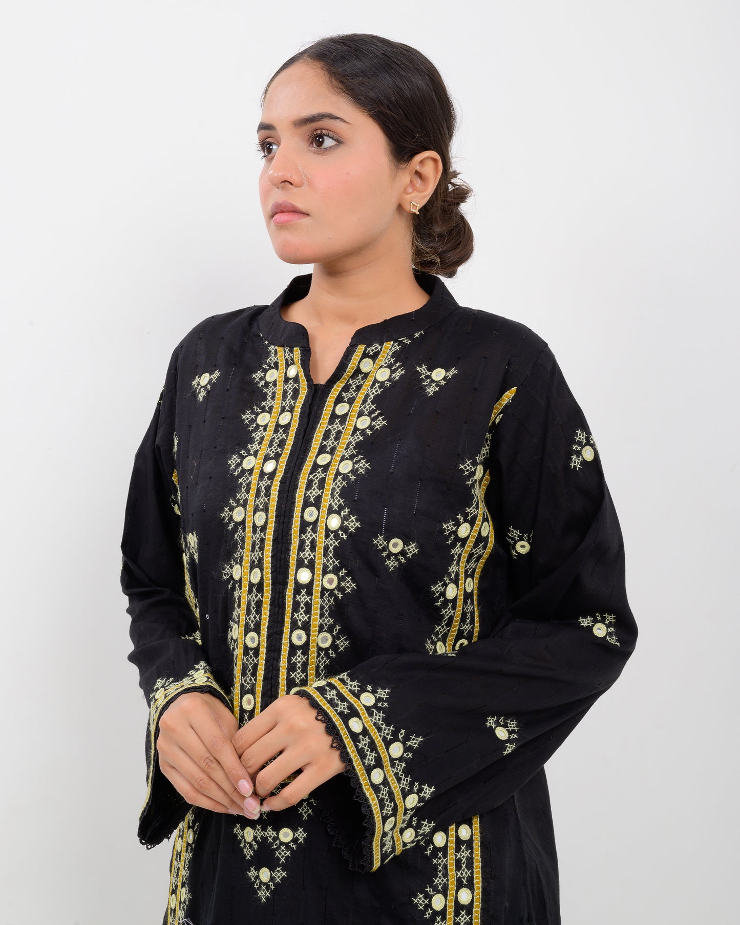 Woman wearing a black balochi embroidered kurta shirt with yellow patterns on a white background