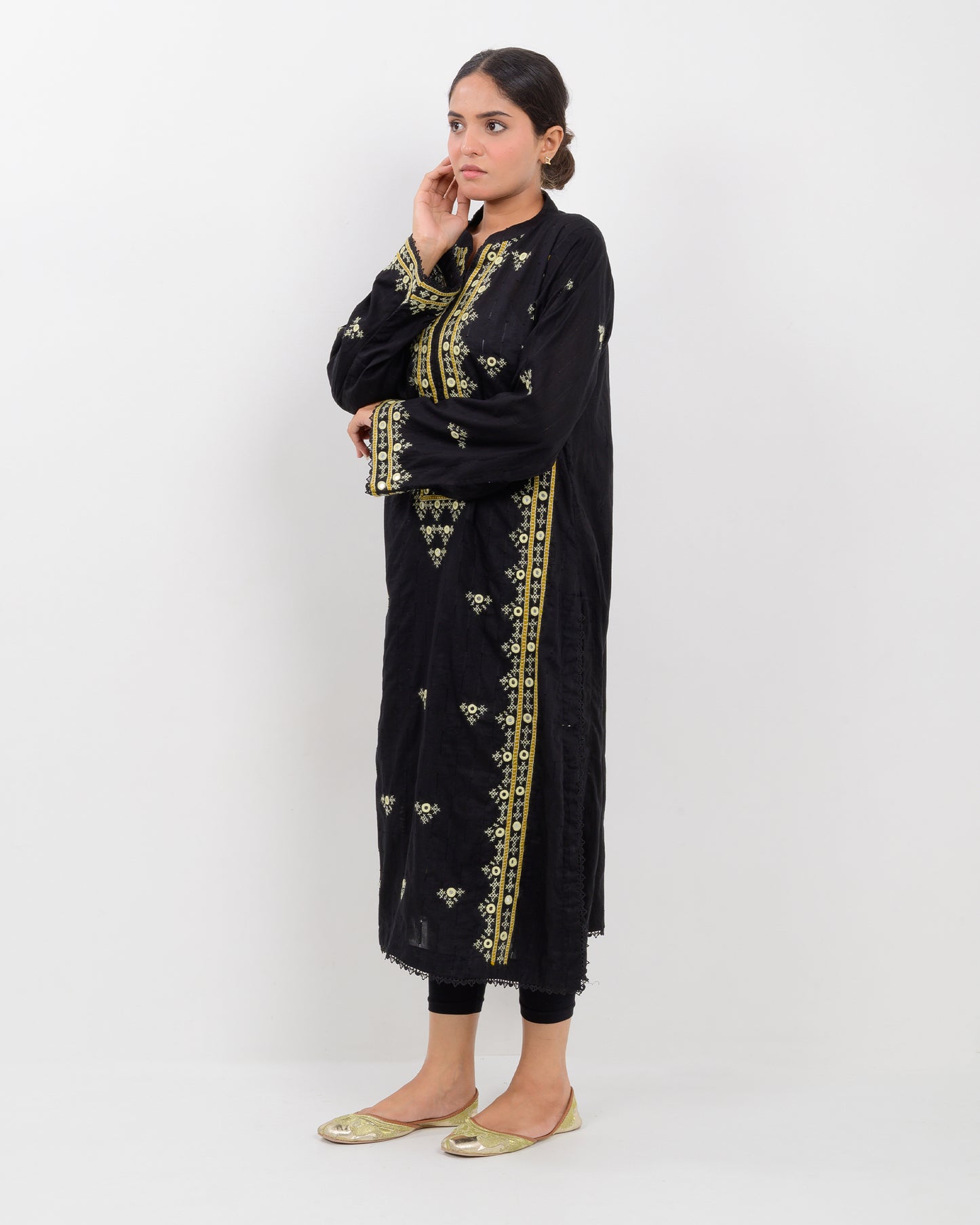 Woman wearing a black balochi embroidered kurta shirt with yellow patterns on a white background