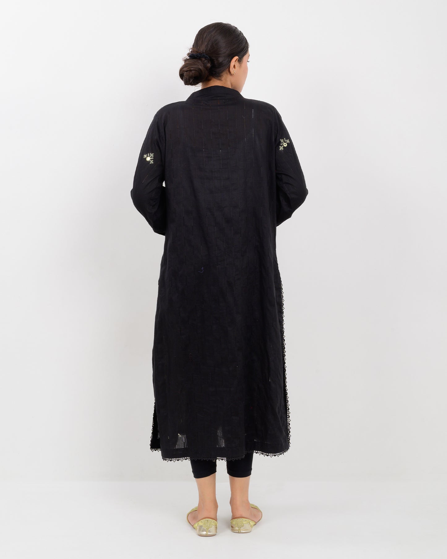 Woman wearing a black balochi embroidered kurta shirt with yellow patterns on a white background