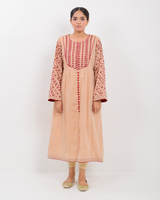 Woman wearing a peach color kachi sui embroidery long shirt on a white background