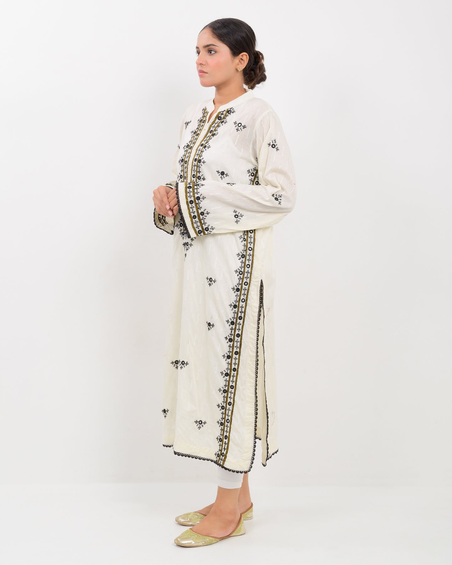 Woman wearing a white balochi embroidered kurta shirt with black patterns on a white background