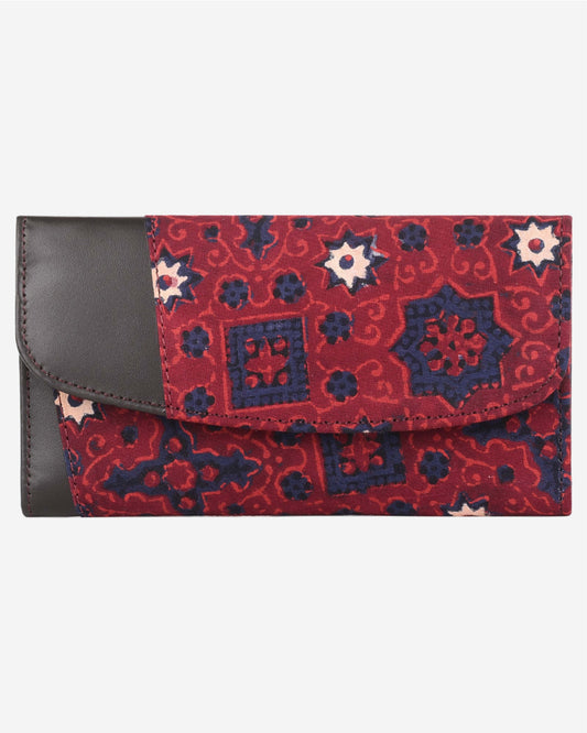 Red and blue patterned clutch bag with a leather flap on a white background