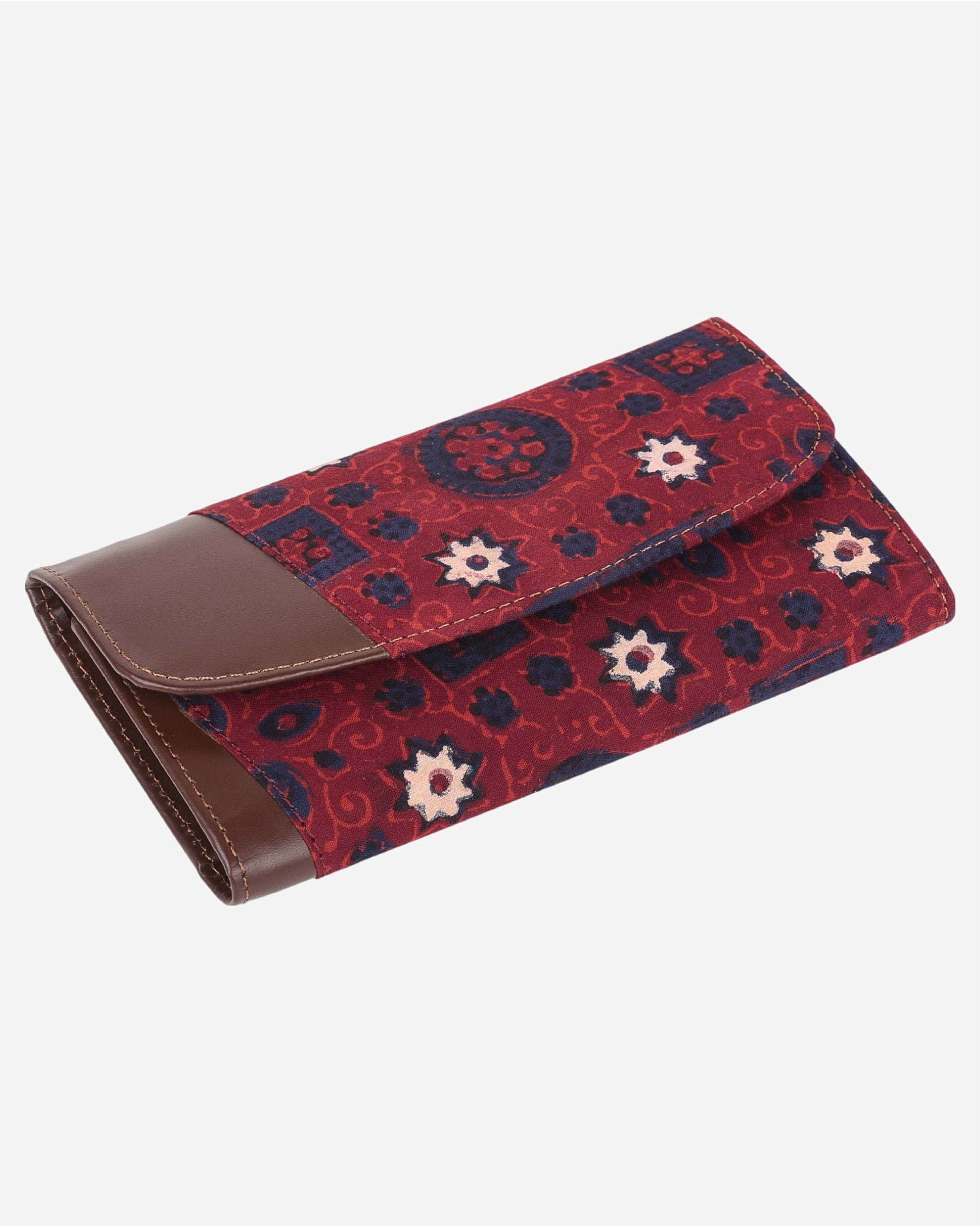 Red and blue patterned clutch bag with a leather flap on a white background