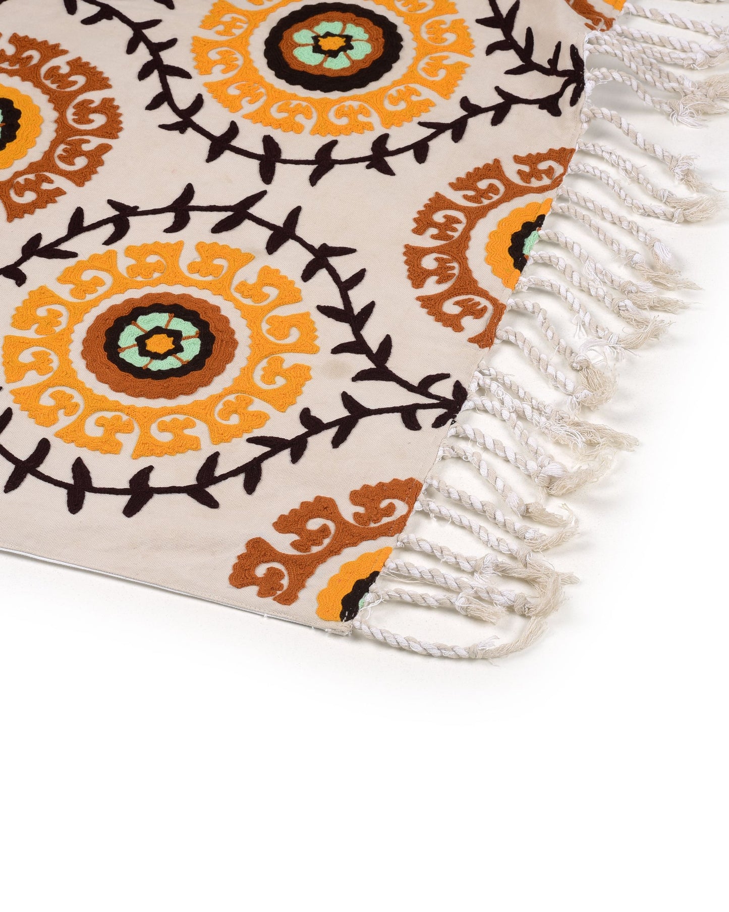 Decorative rug with intricate patterns and fringes on a white background