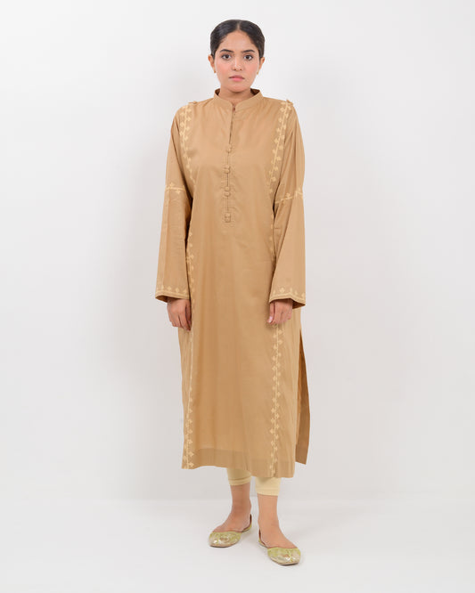 Woman wearing a beige Hurmich Embroidery shirt on white background