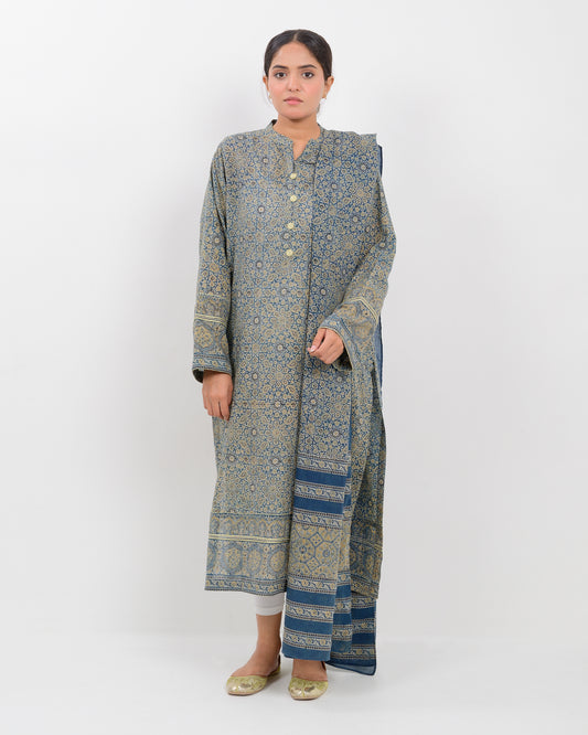 Woman wearing a long, patterned dress with a matching shawl on a white background