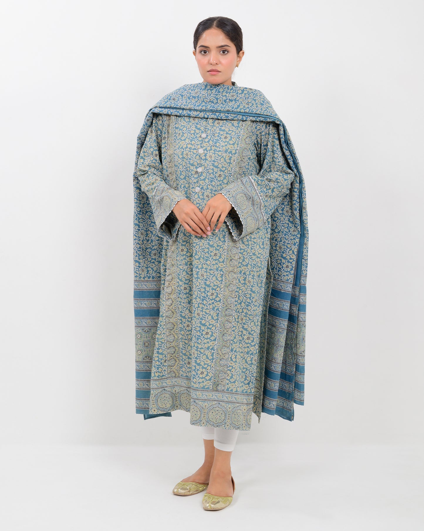 Woman wearing a long, patterned dress with a dupatta against a white background