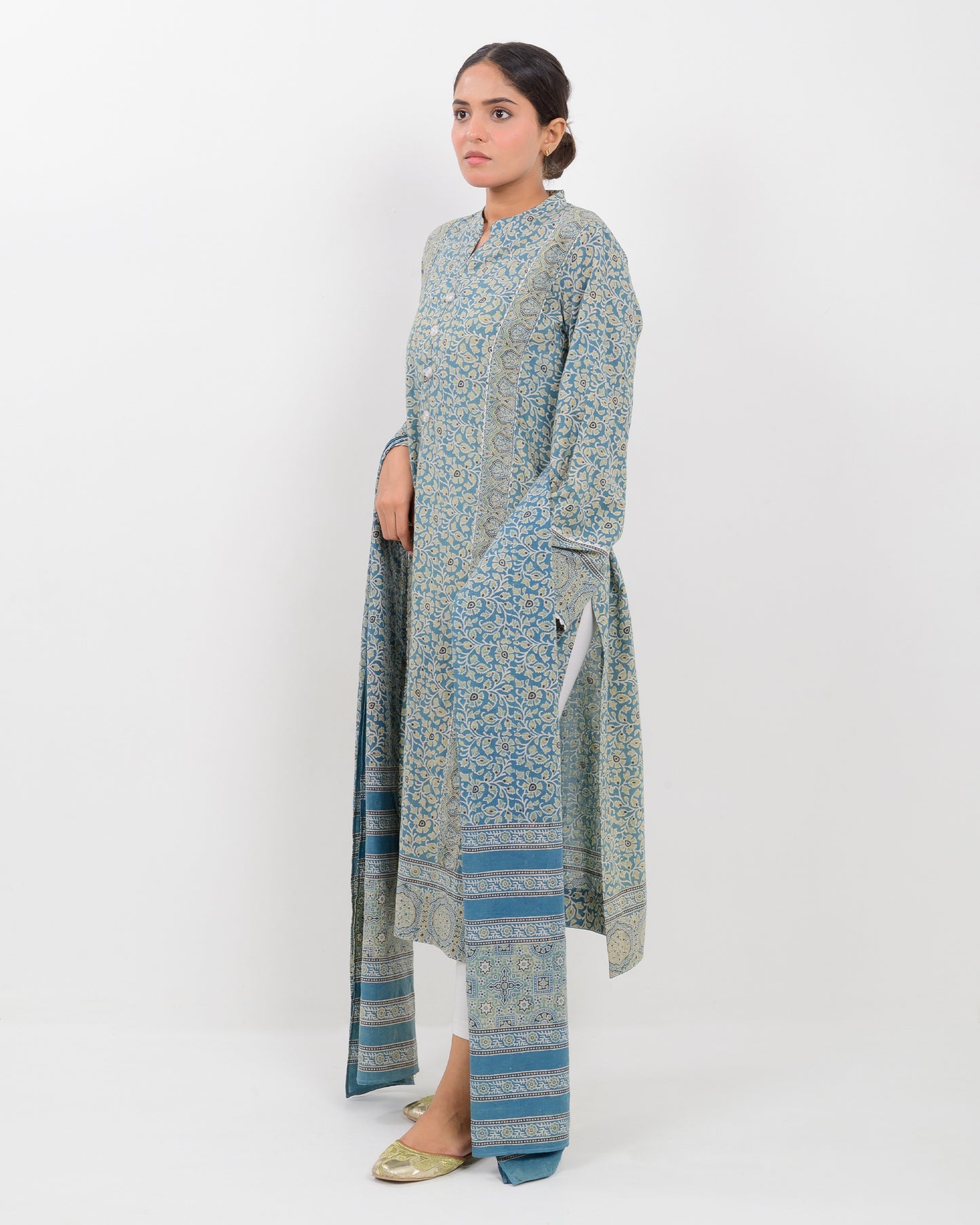 Woman wearing a long, patterned dress with a dupatta against a white background
