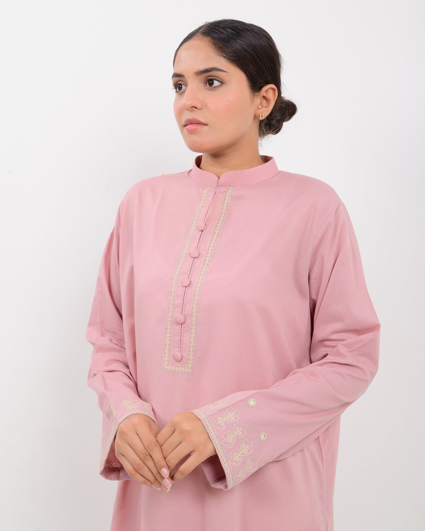 Woman wearing a pink Hurmich craft mirror work shirt with a white background