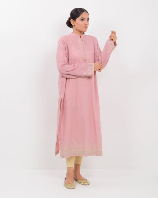 Woman wearing a pink Hurmich craft mirror work  shirt with a white background