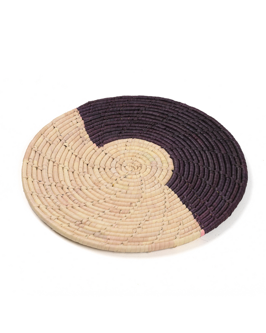 Round woven mat with two-tone design on a white background