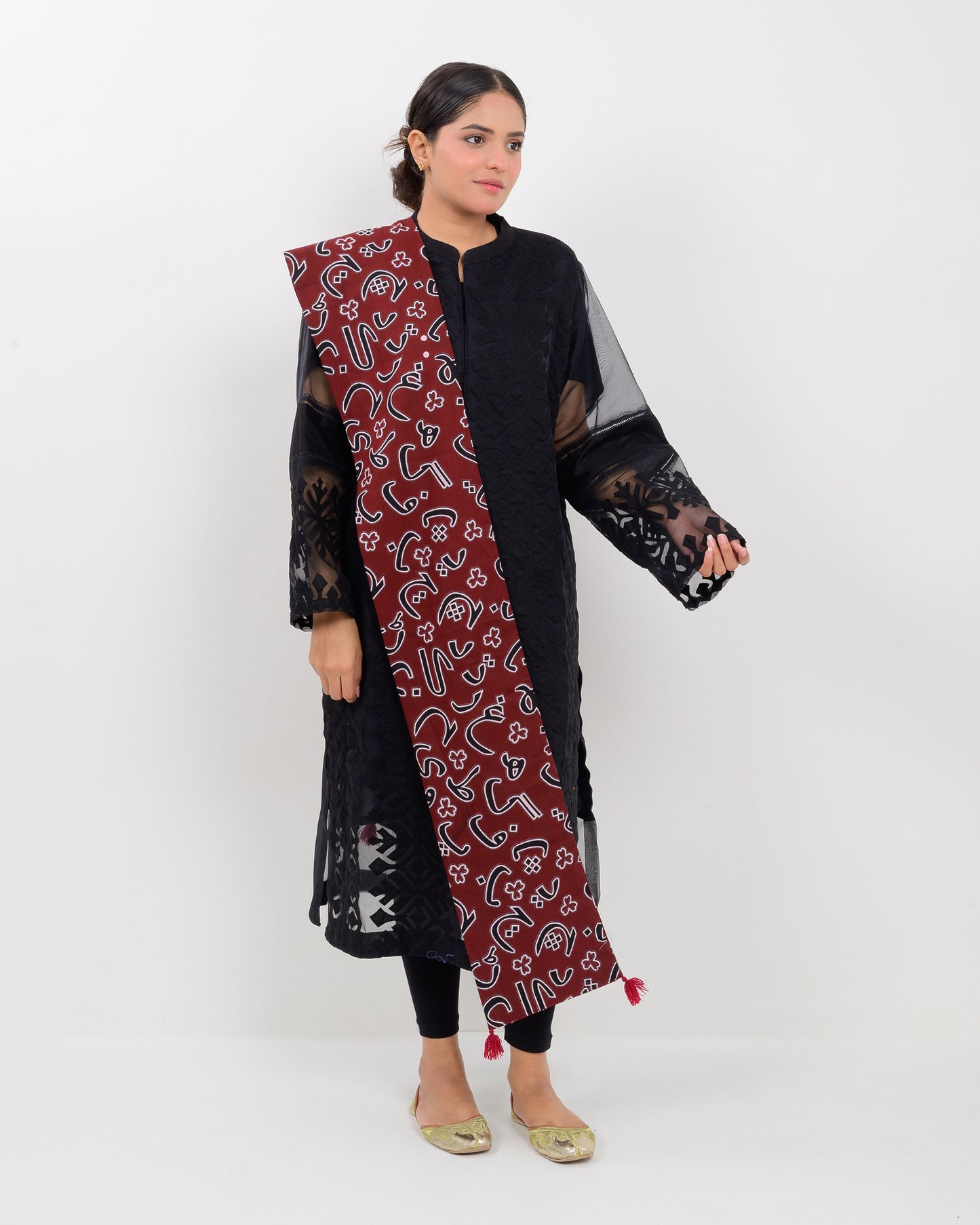 A woman wearing a black outfit with a Red color Sindhi script, stole on a white background.