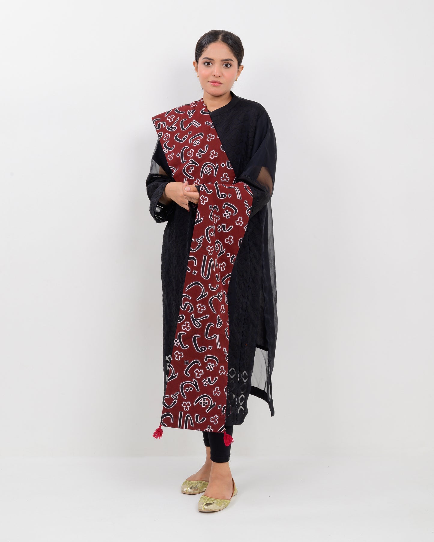 A woman wearing a black outfit with a Red color Sindhi script, stole on a white background.