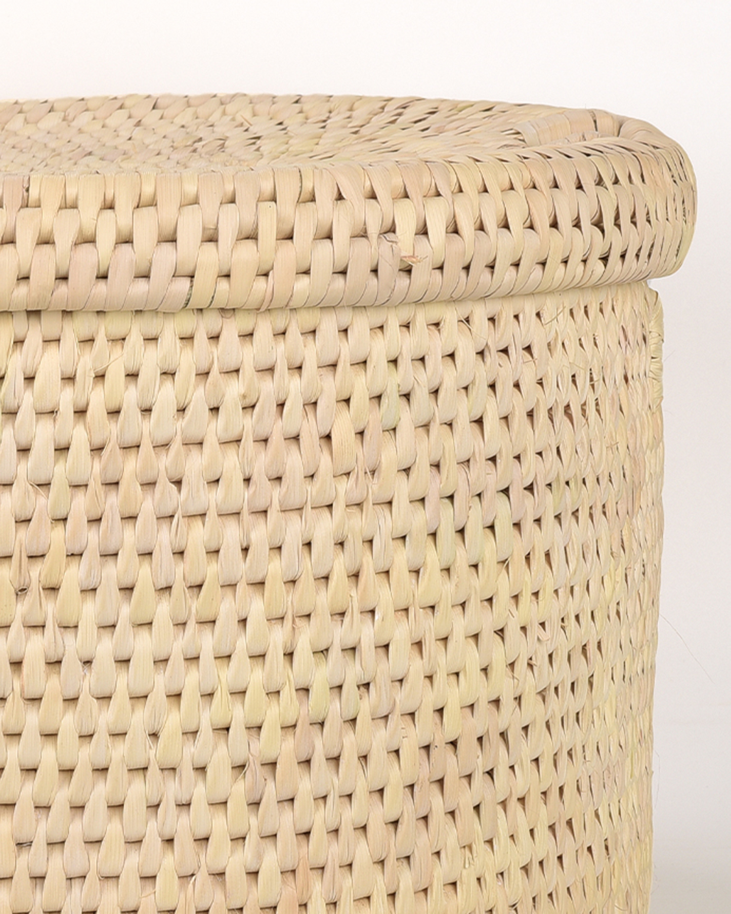Close-up of a woven beige storage basket with a white background