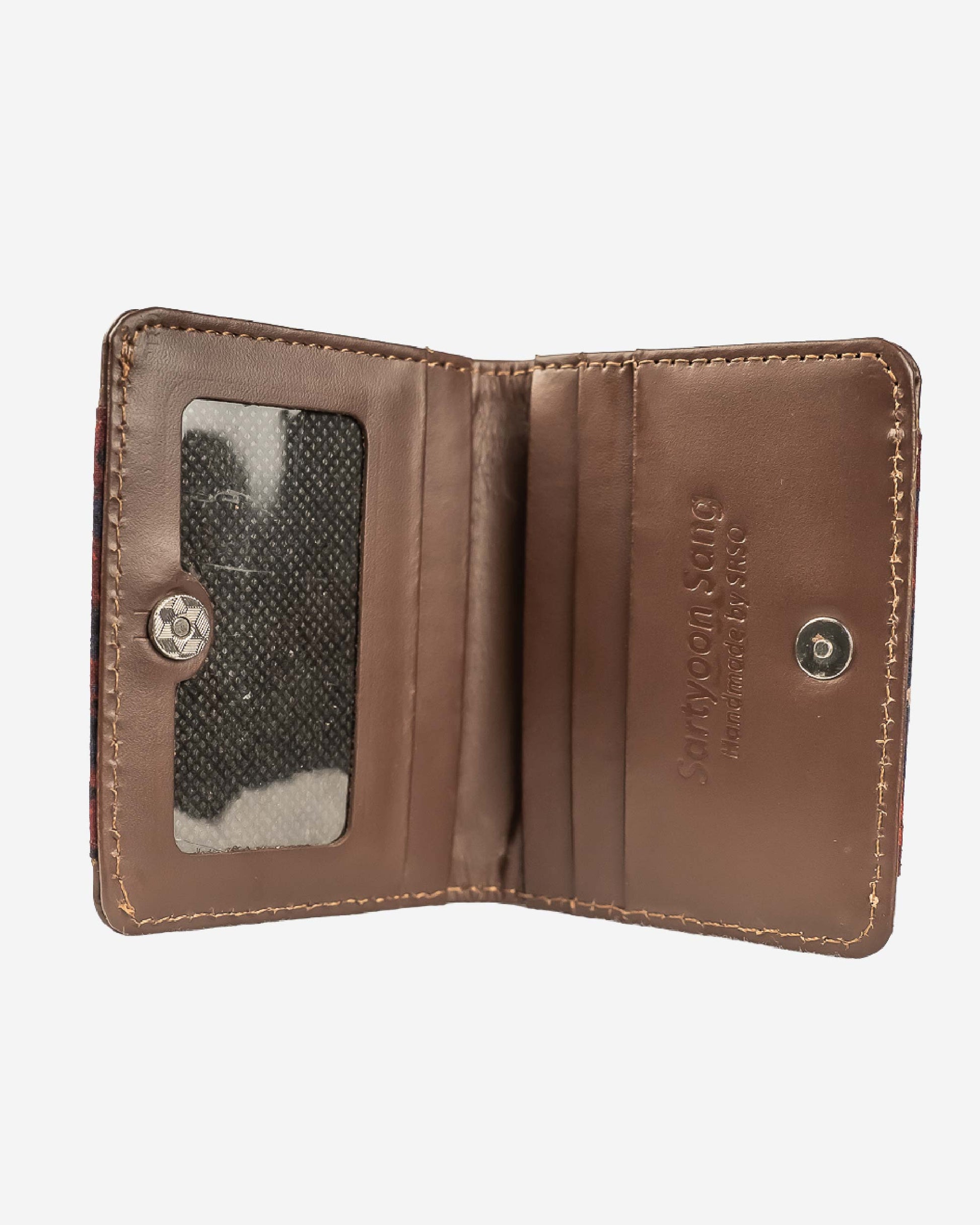 Cardholder with an ajrak block print patterned front and brown leather sides on a white background