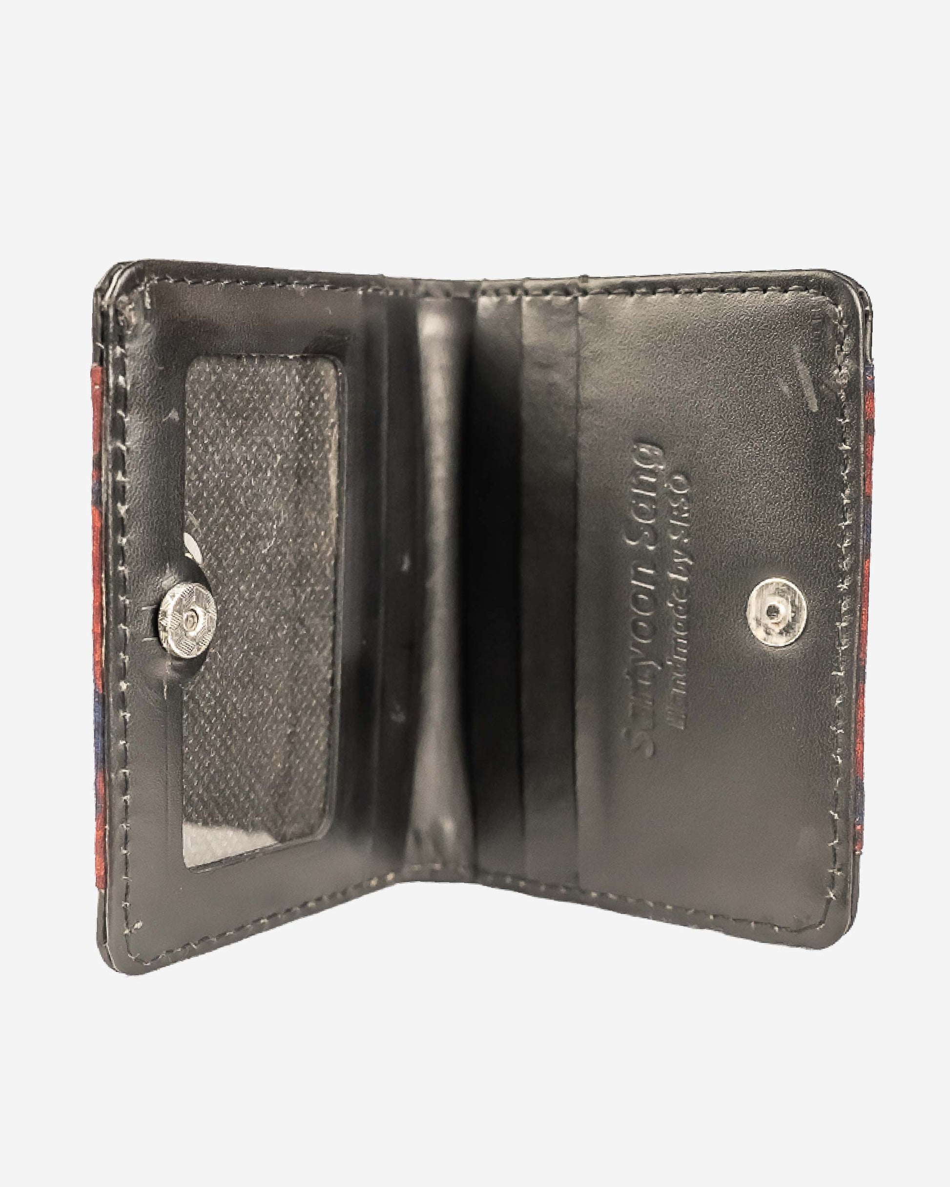 Cardholder with an ajrak block print patterned front and brown leather sides on a white background