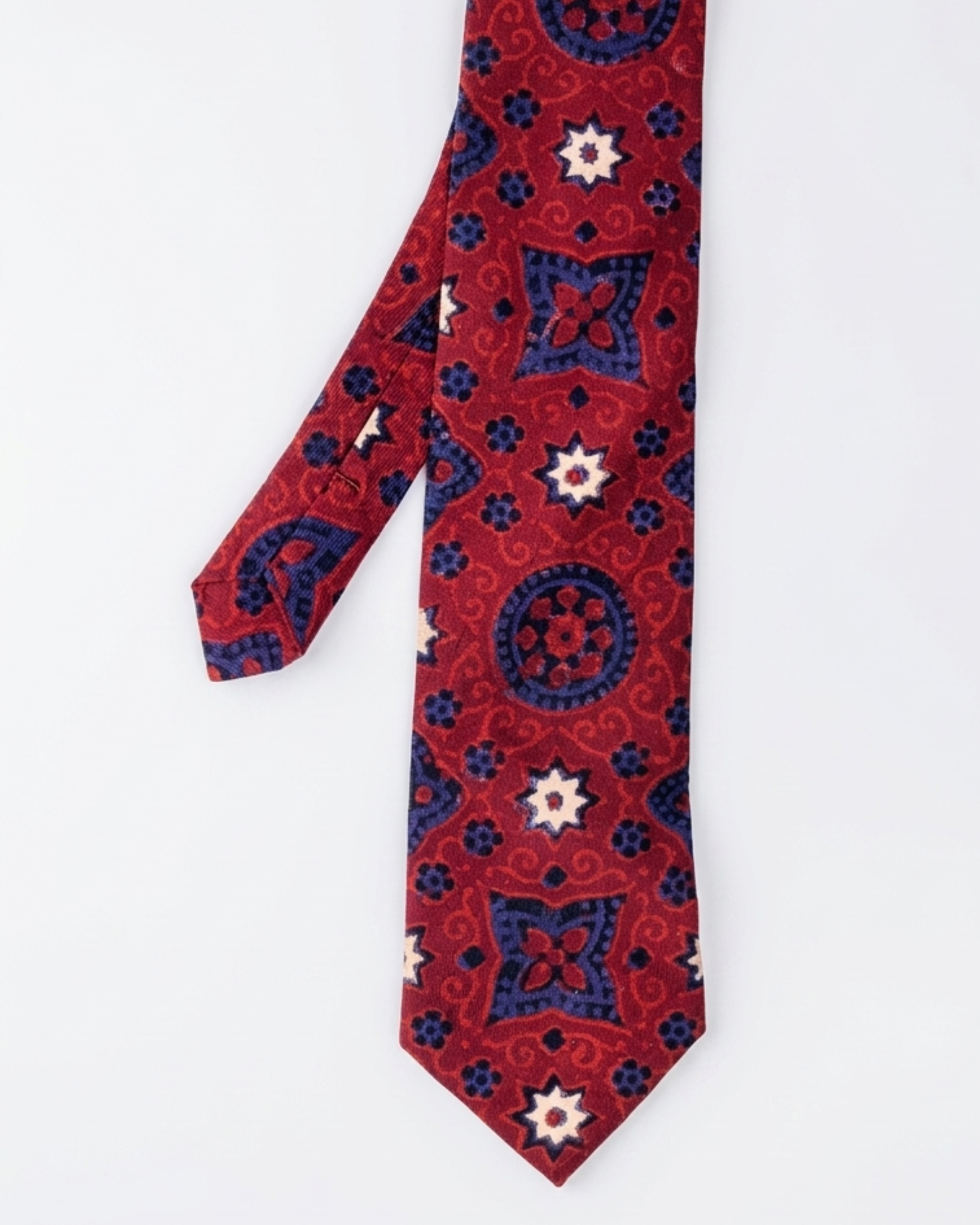 Ajrak hand block print cotton tie in crimson red with indigo geometric medallions and floral motifs, handcrafted in Sindh Pakistan