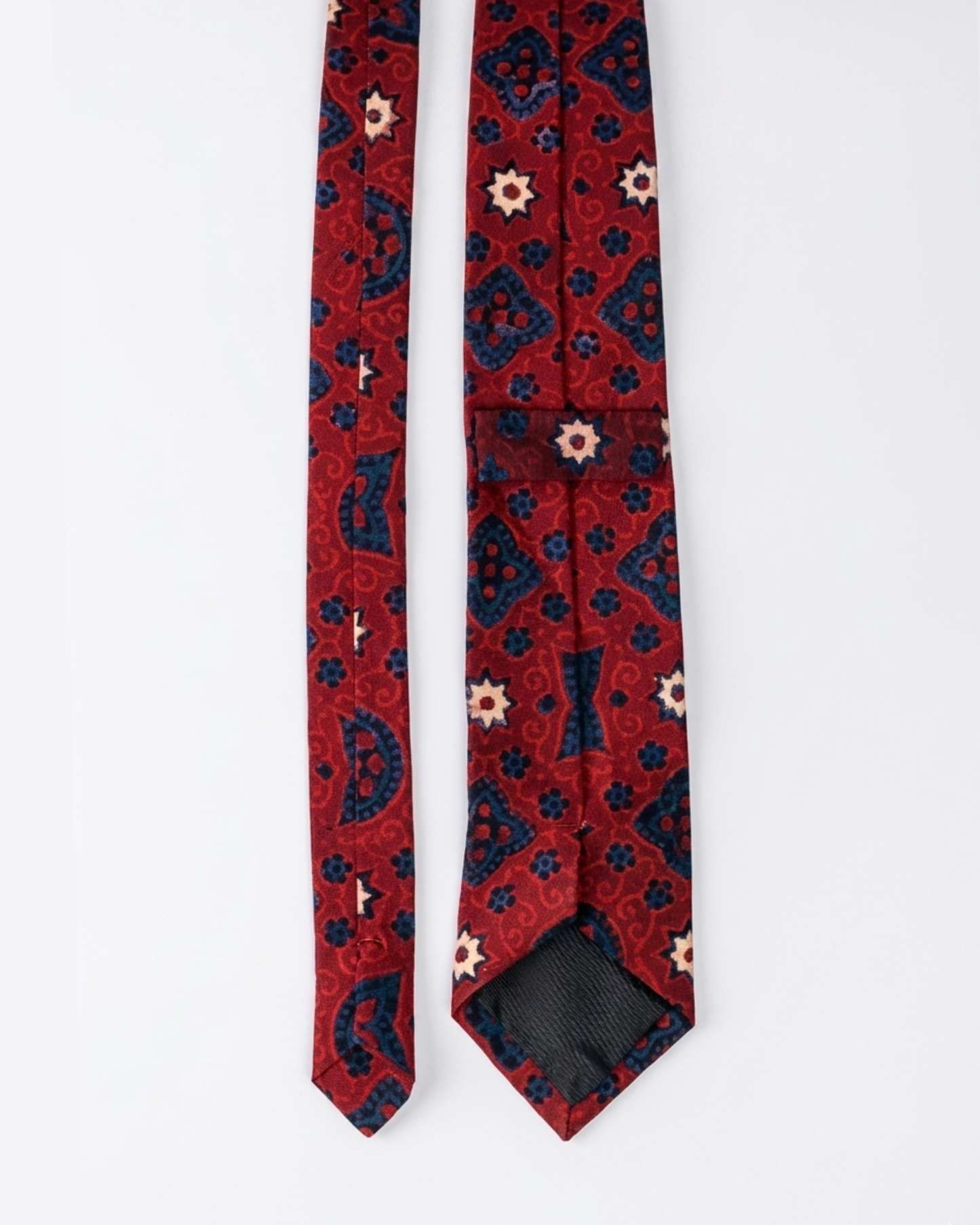 Ajrak hand block print cotton tie in crimson red with indigo geometric medallions and floral motifs, handcrafted in Sindh Pakistan