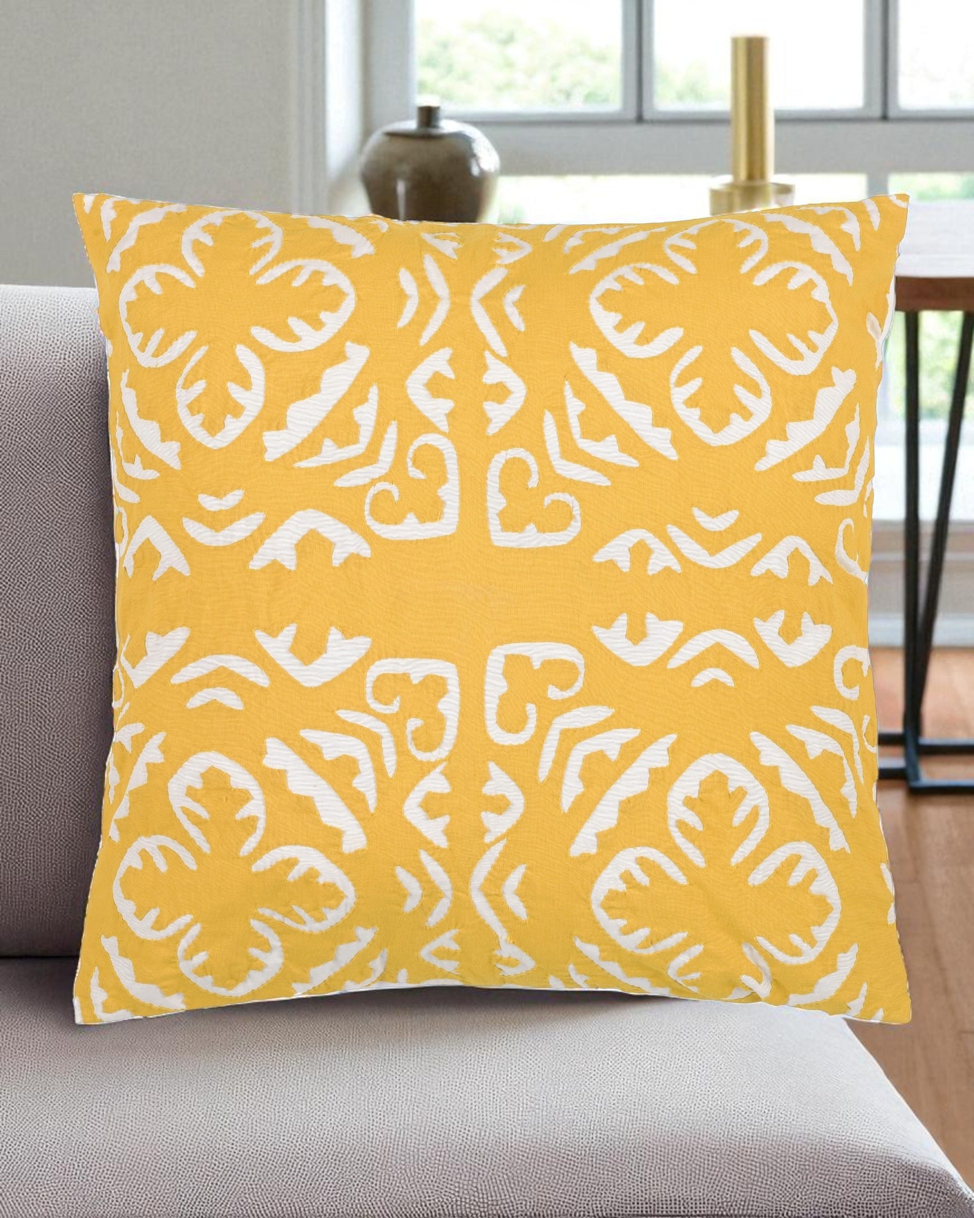 Yellow pillow with white pattern on a gray couch