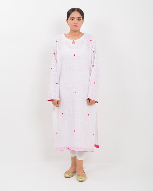 A woman wearing a white shirt with pink embroidery on a white background
