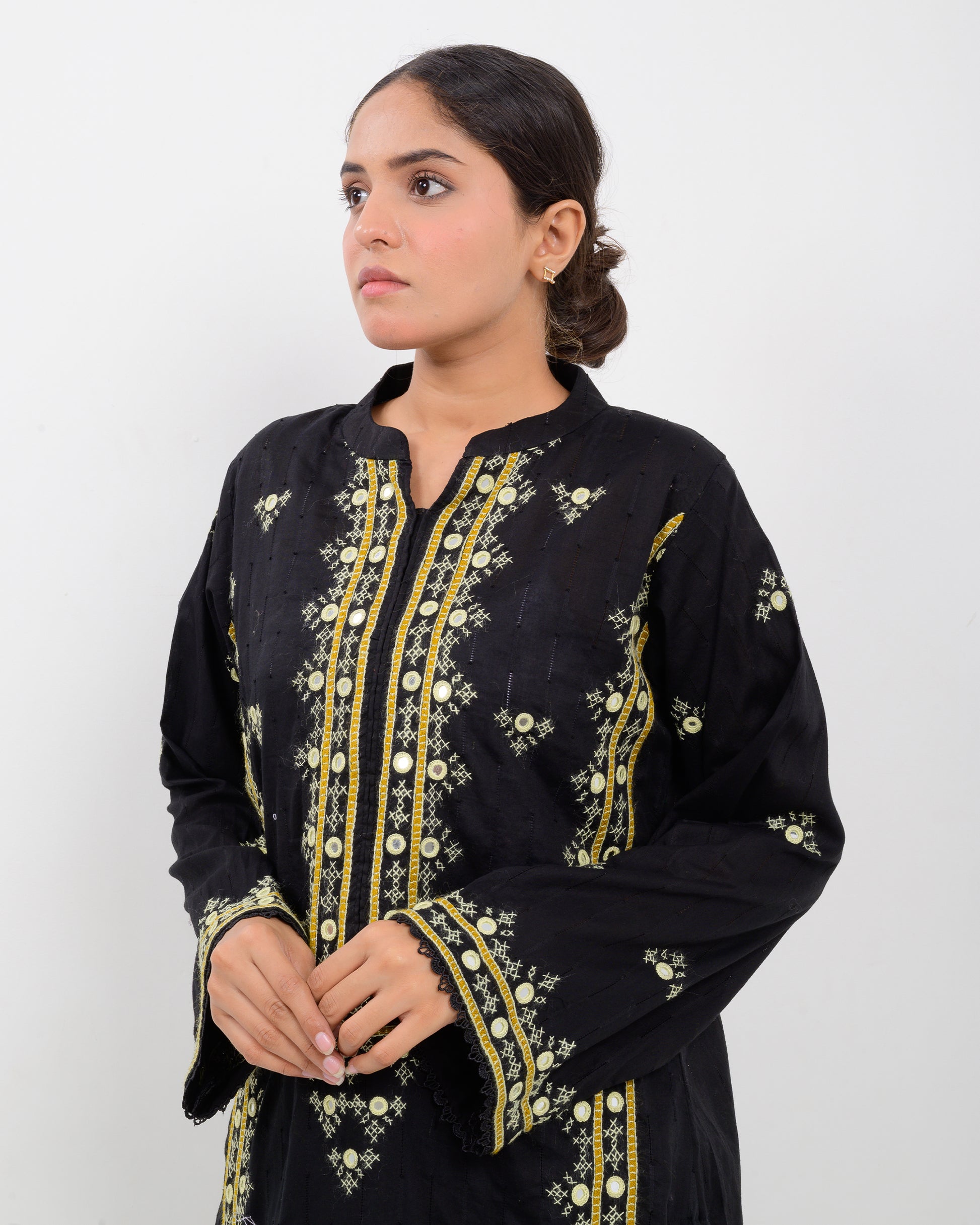 Woman wearing a black balochi embroidered kurta shirt with yellow patterns on a white background