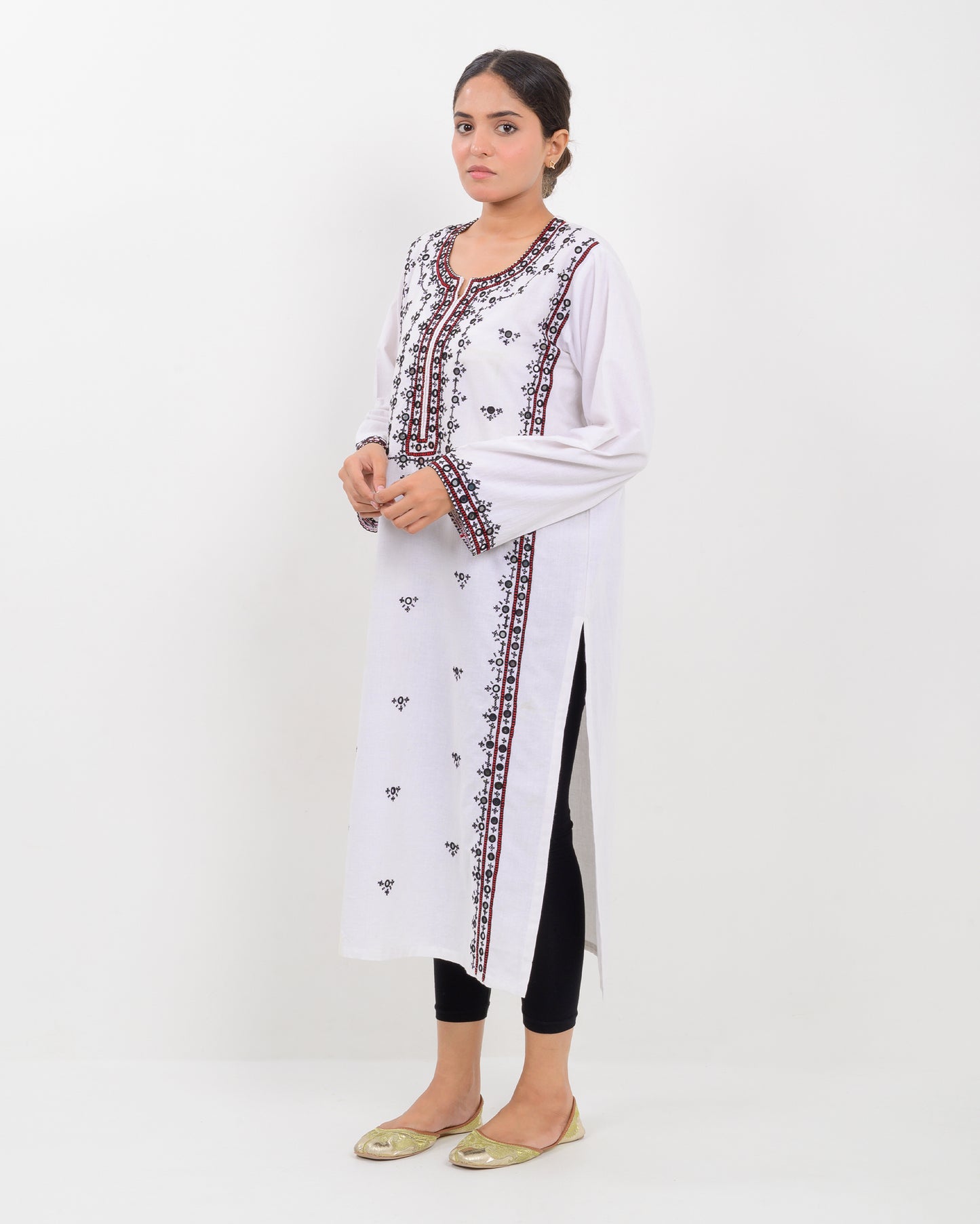 Woman wearing a white Shirt with black and red embroidery on a white background