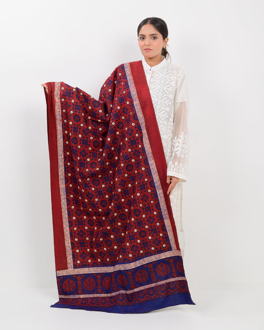 Woman holding a Sindhi traditional block print ajrak shawl against a white background