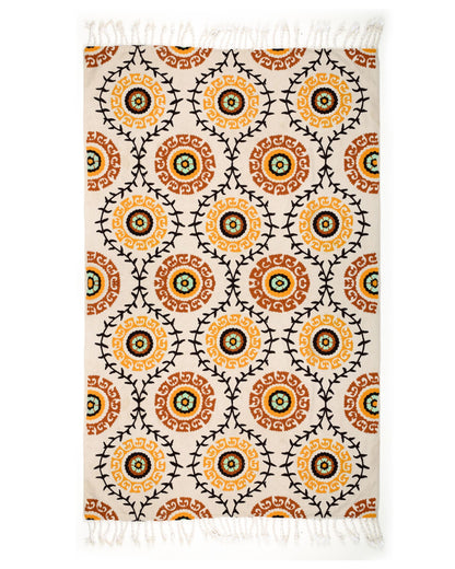 Patterned rug with orange and black circles on a white background