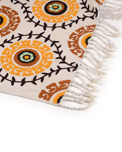 Decorative rug with intricate patterns and fringes on a white background