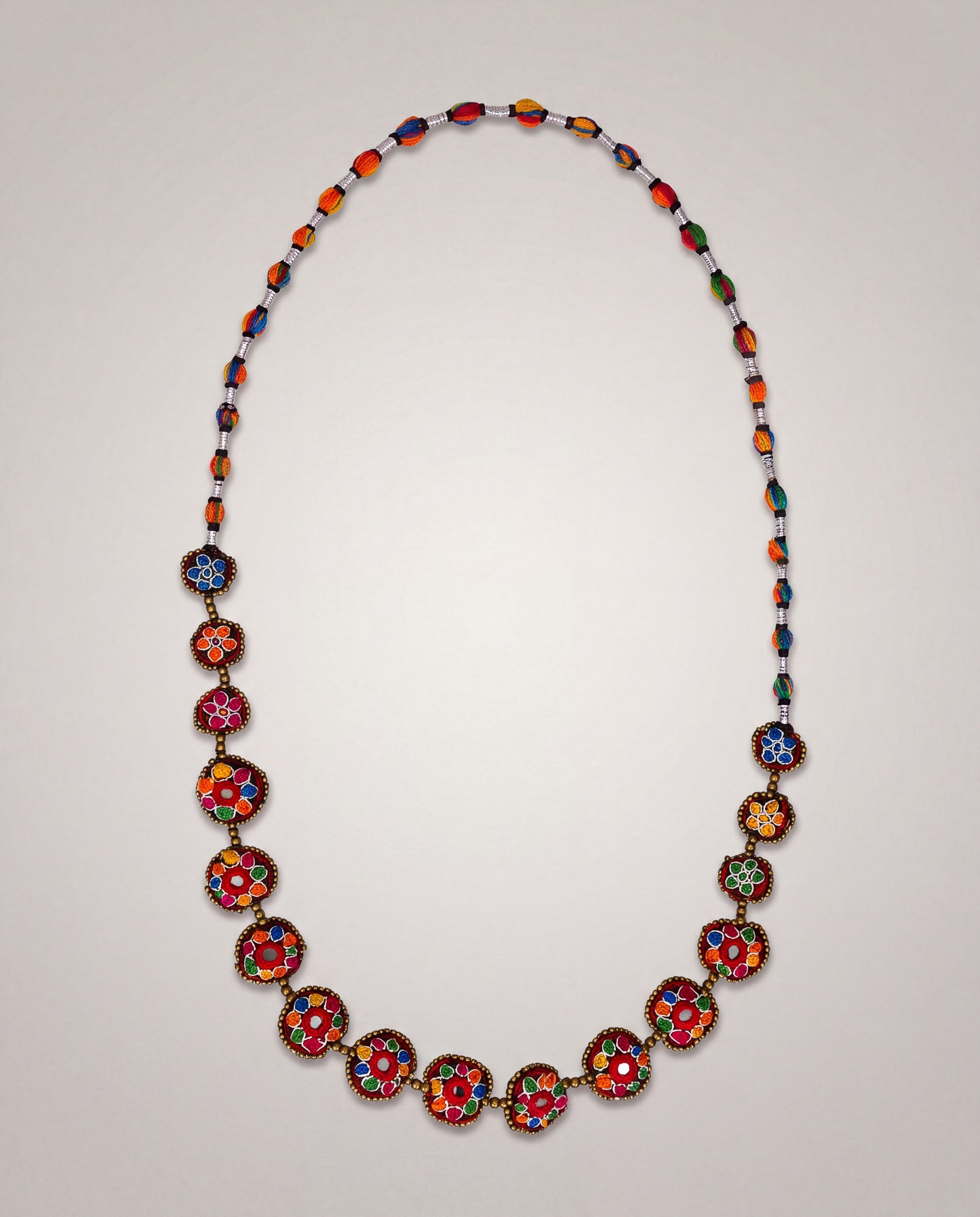 Handmade Balochi mirror flower necklace with colorful embroidered floral motifs, golden beads, silver thread, and traditional artisan craftsmanship from Pakistan.