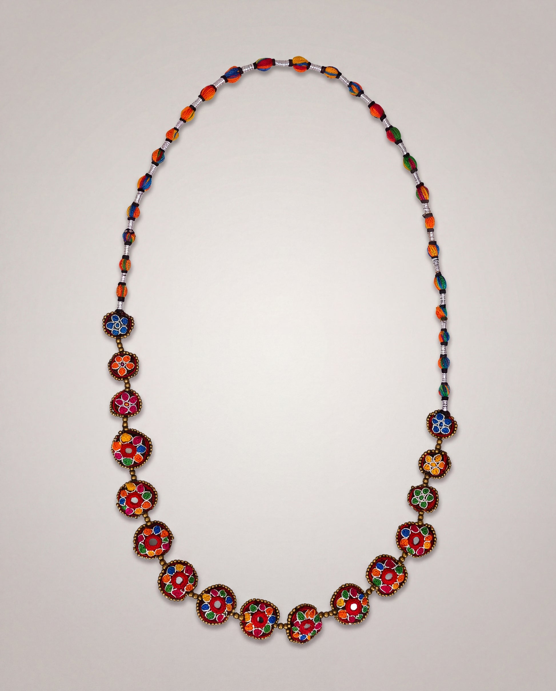Handmade Balochi mirror flower necklace with colorful embroidered floral motifs, golden beads, silver thread, and traditional artisan craftsmanship from Pakistan.