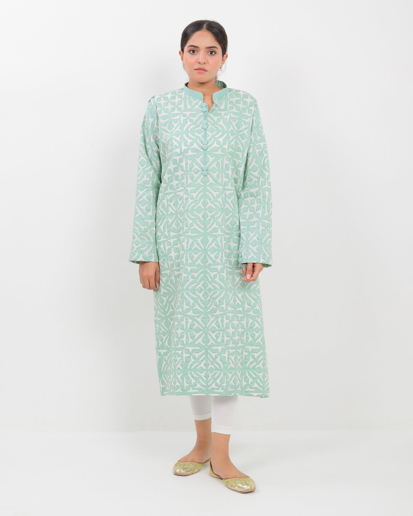 Woman wearing a light green applique cutwork craft shirt on a white background