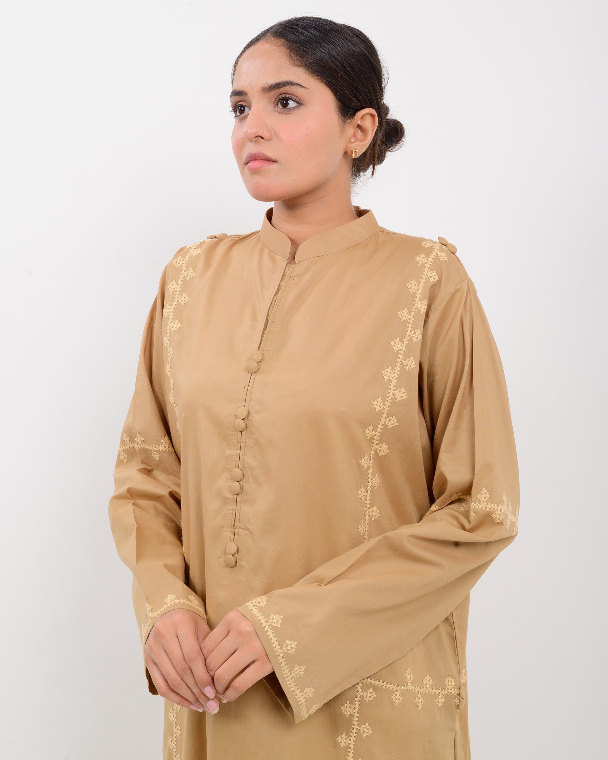 Woman wearing a beige Hurmich Embroidery shirt on white background