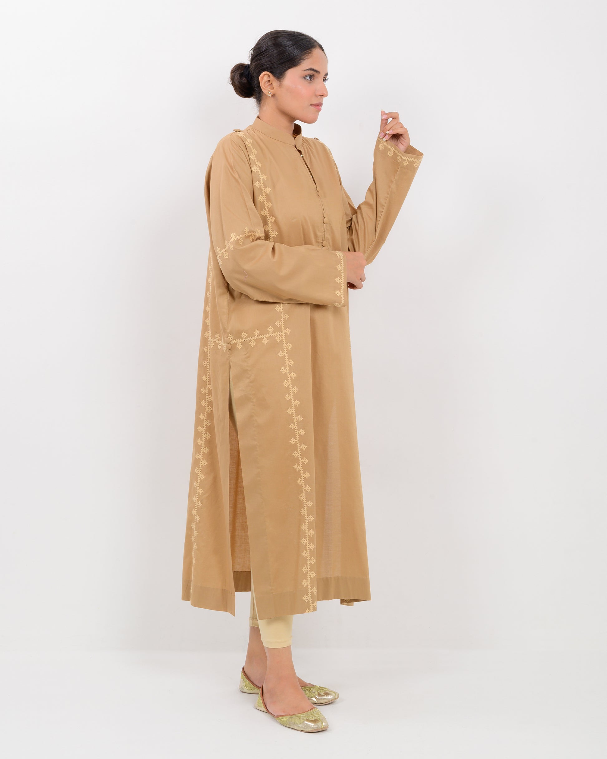 Woman wearing a beige Hurmich Embroidery shirt on white background