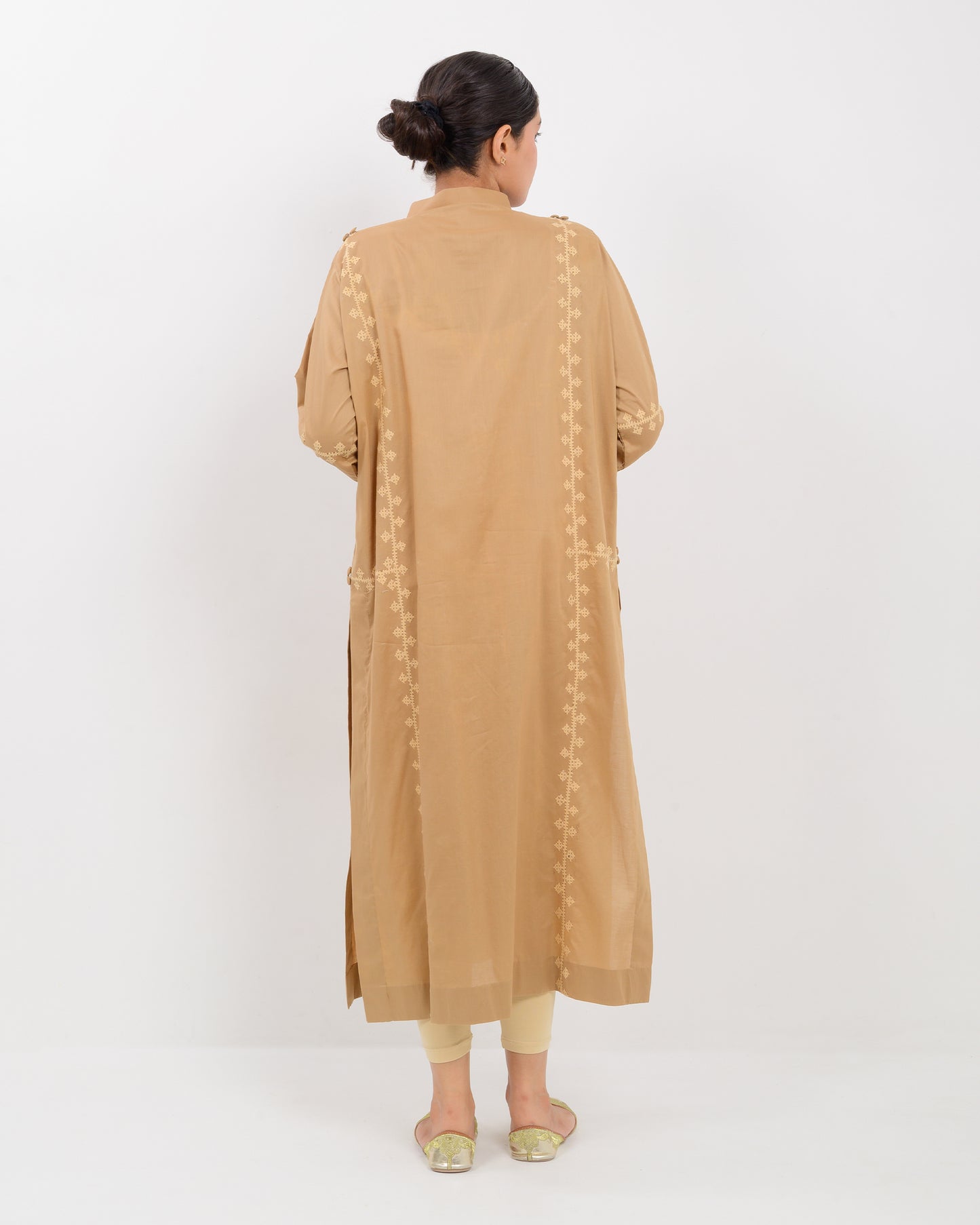Woman wearing a beige Hurmich Embroidery shirt on white background