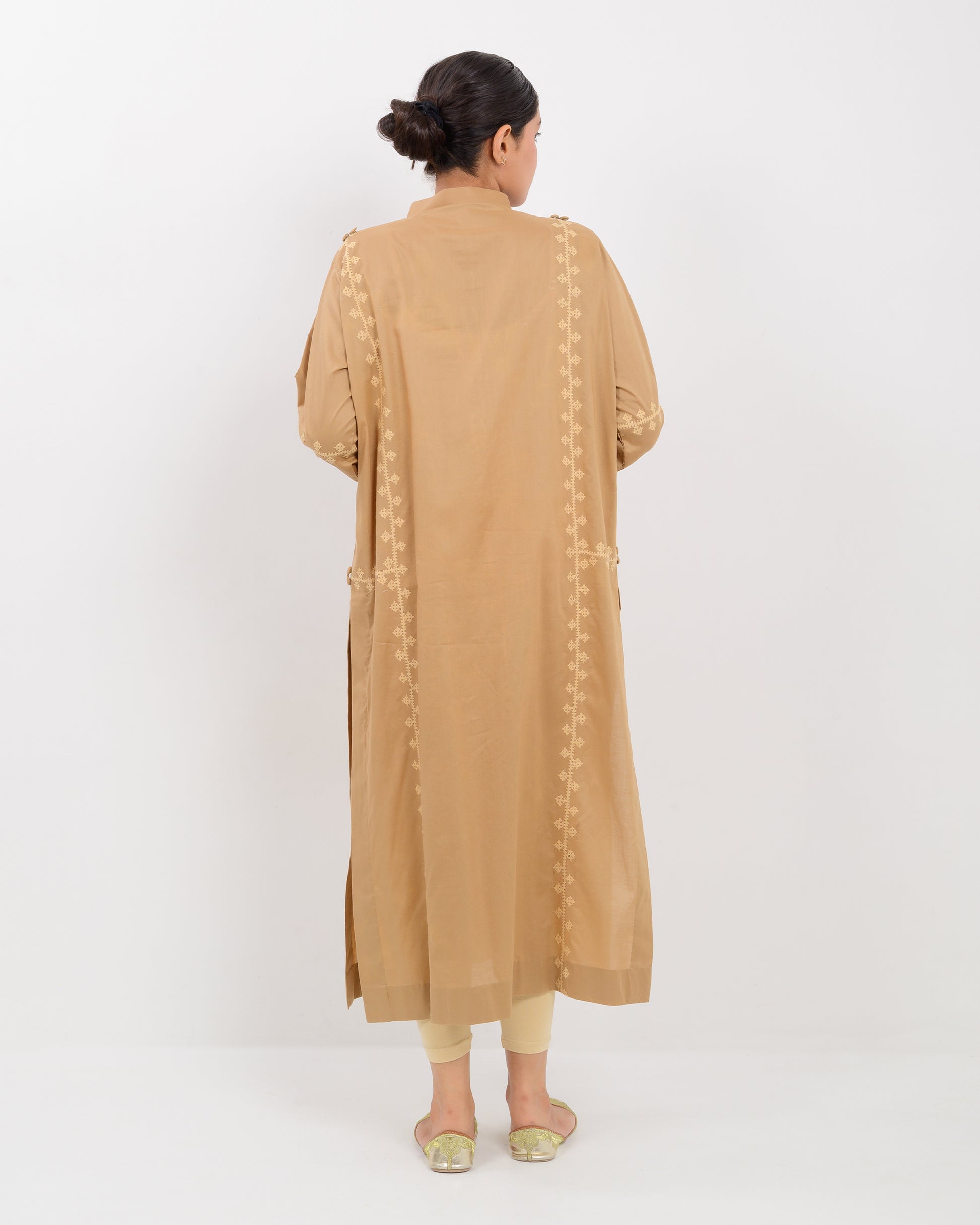 Woman wearing a beige Hurmich Embroidery shirt on white background