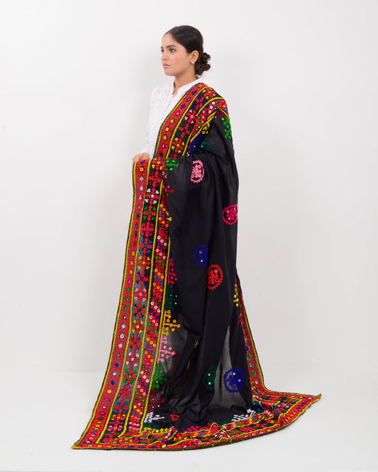 Woman wearing a black embroidered hummich mirror work shawl on a white background