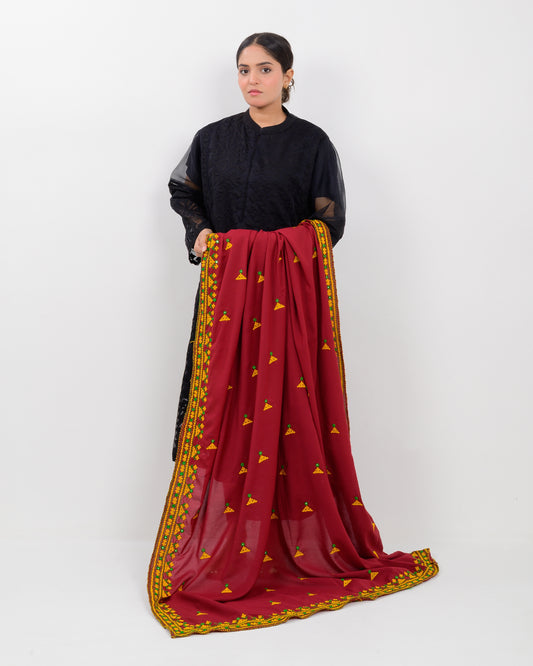 Woman holding a maroon color with yellow hurmich embroidery shawl on a white background