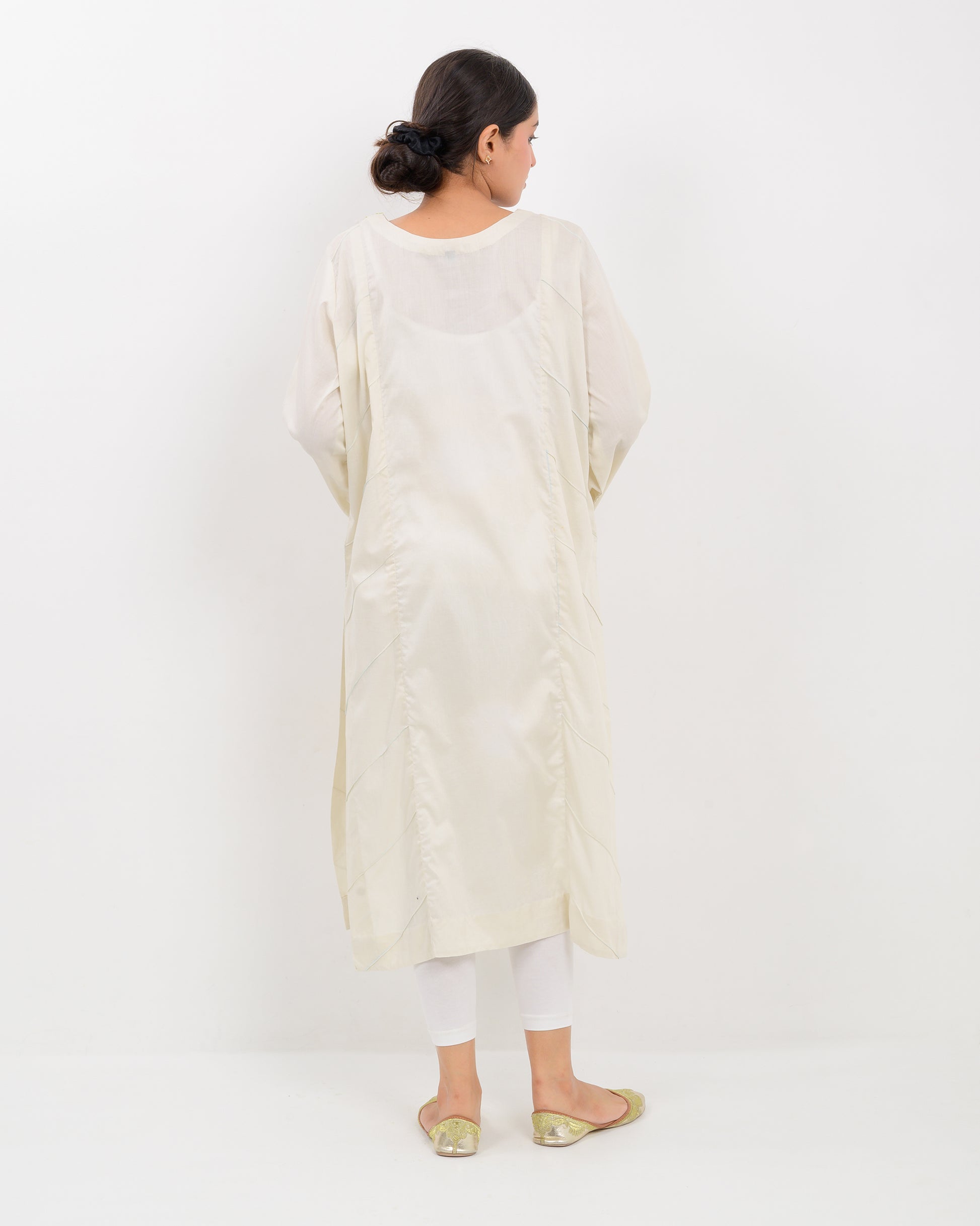 Woman wearing a light green kachi sui embroidery shirt on a white background
