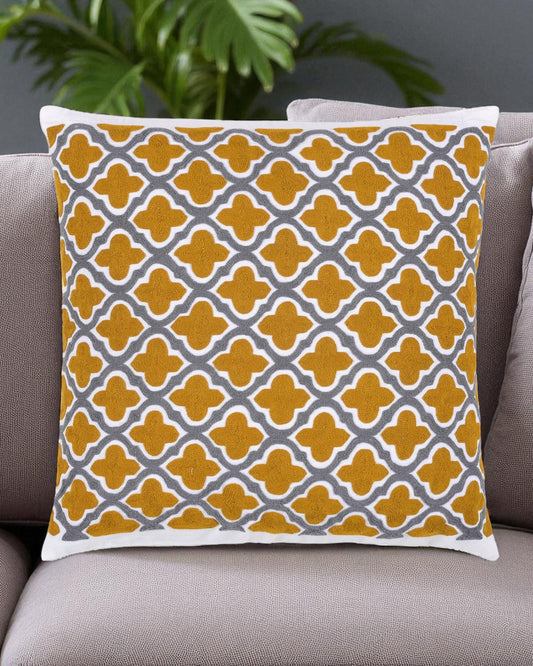 Decorative pillow with yellow and gray pattern on a gray sofa