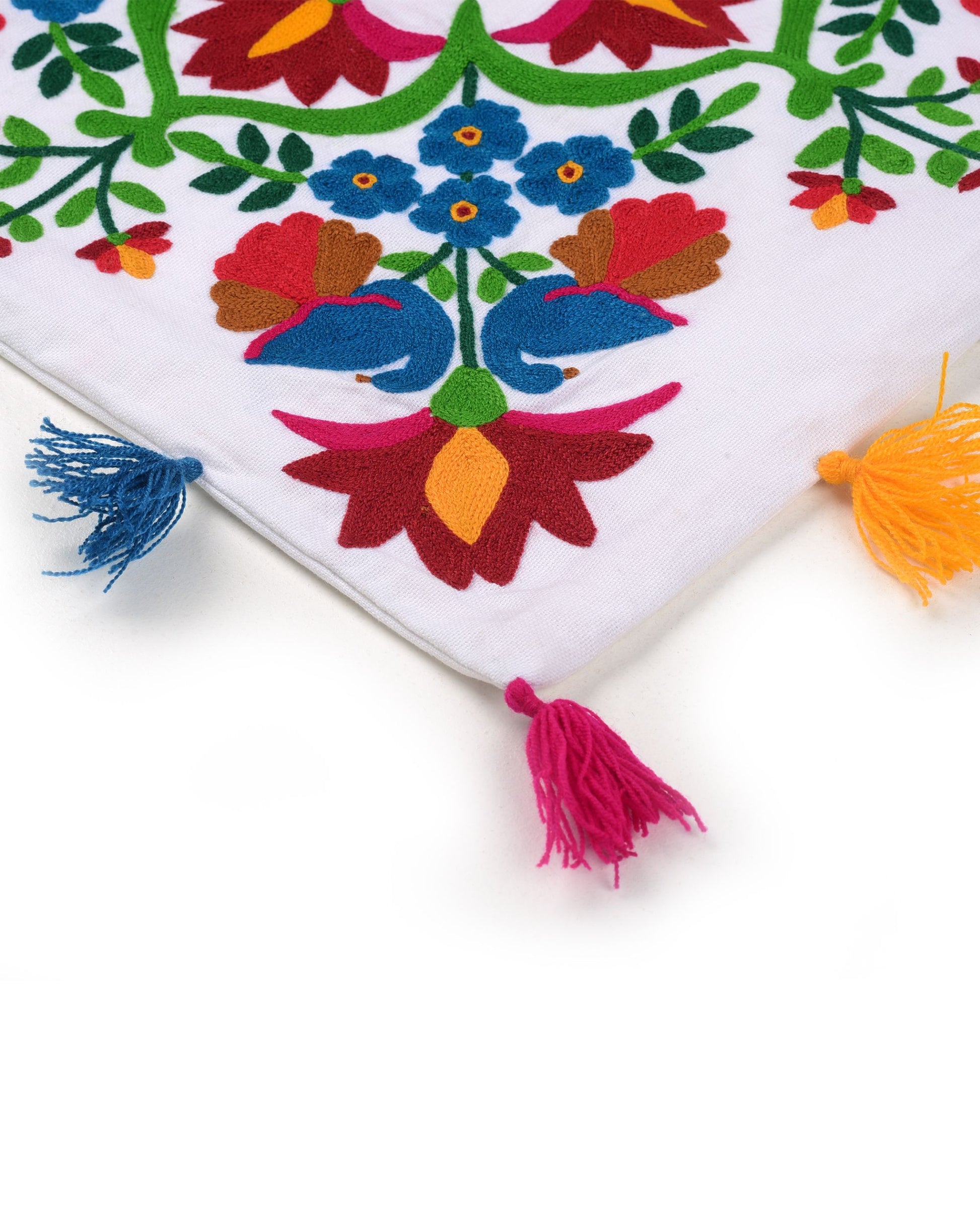 Colorful embroidered fabric with floral patterns and tassels on a white background