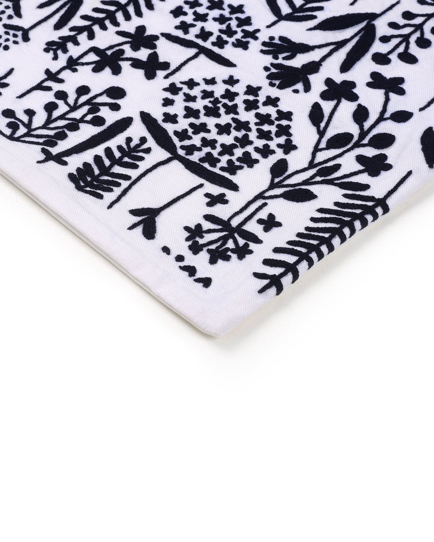 Close-up of a white ceramic cushion cover  with black floral pattern