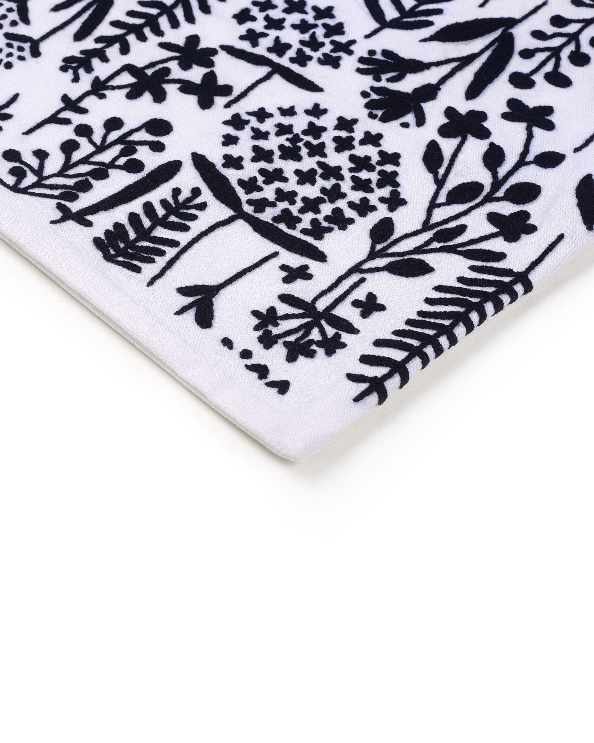 Close-up of a white ceramic cushion cover  with black floral pattern
