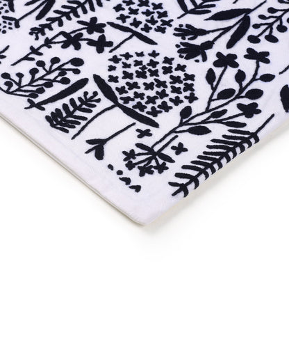 Close-up of a white ceramic cushion cover  with black floral pattern