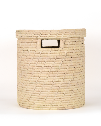 Woven beige basket with a handle on a white background