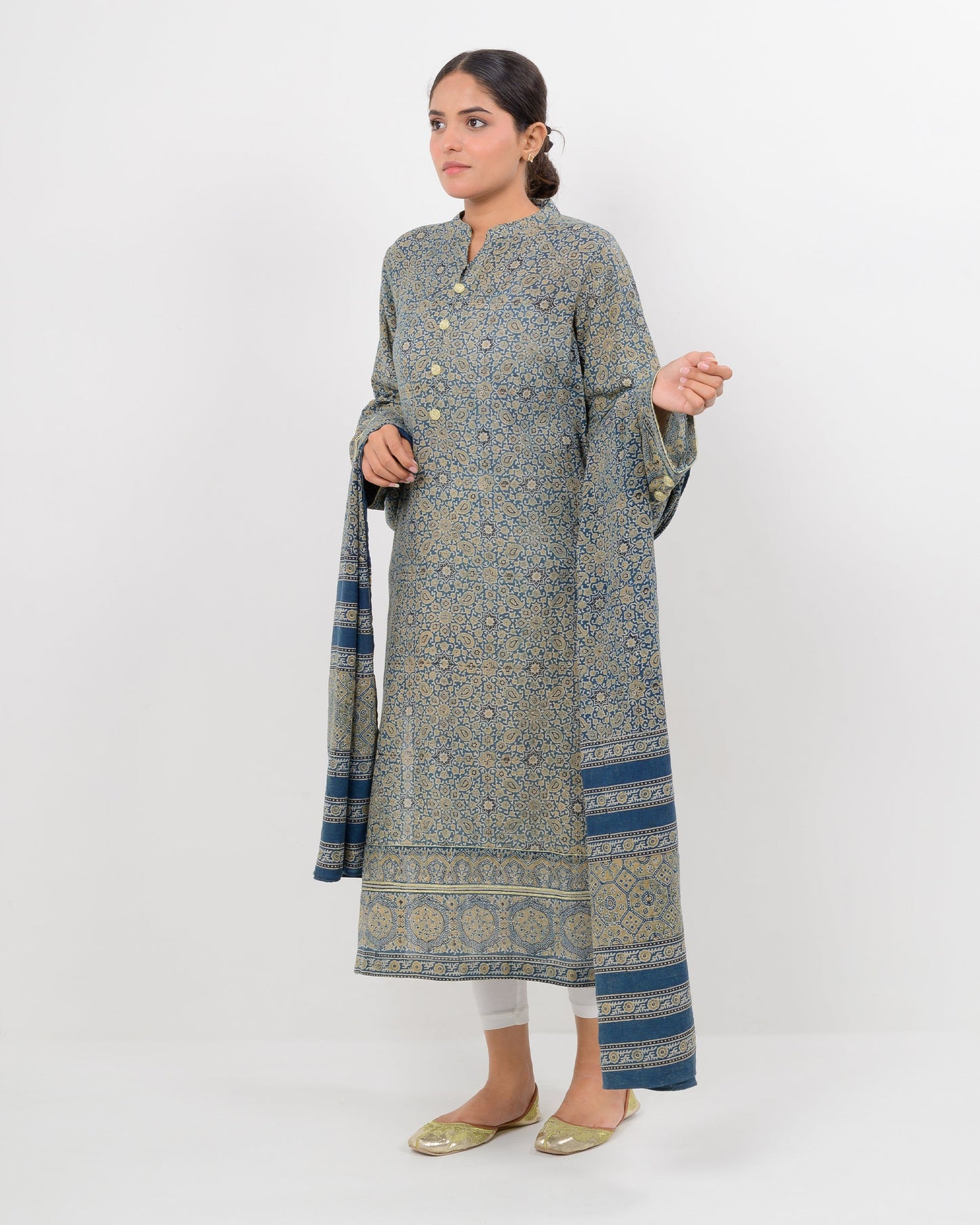 Woman wearing a long, patterned dress with a matching shawl on a white background