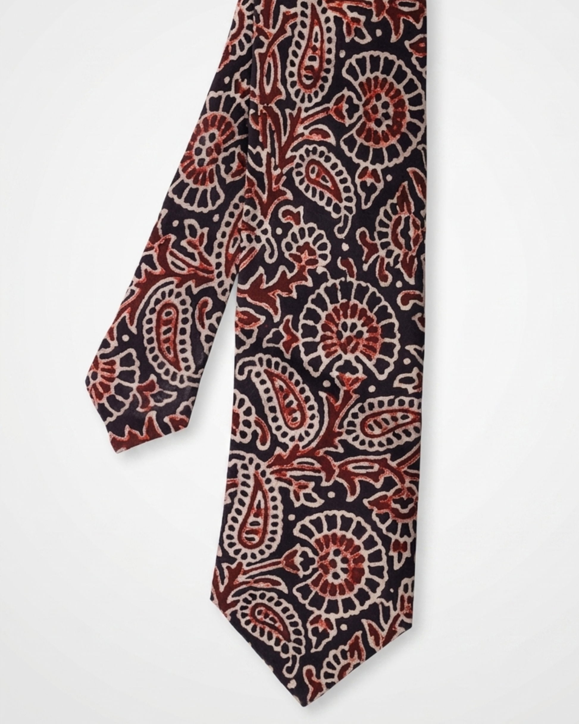 Natural dye hand block print silk tie with near black base and oversized paisley floral motifs in terracotta burnt sienna and antique cream handcrafted in Sindh Pakistan